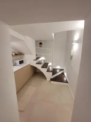 a staircase in a kitchen with white walls at Mini Loft MaDi' in Rome