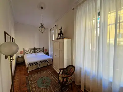 a bedroom with a bed and a window with curtains at Angel's Garden in Rome