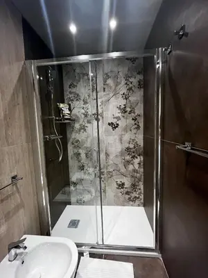 a shower with a glass door next to a sink at Stazione Tiburtina Roma in Rome