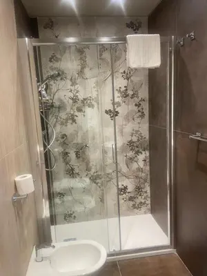 a bathroom with a shower with a toilet and a sink at Stazione Tiburtina Roma in Rome