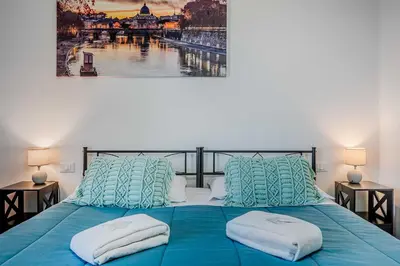 a bedroom with a blue bed with two pillows at Domus Antica Trastevere in Rome