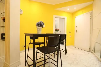 a dining room with yellow walls and a black table and chairs at Domus Antica Trastevere in Rome