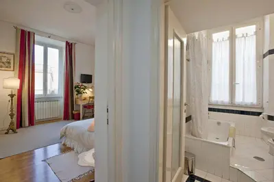 a bathroom with a tub and a sink and a bed at B&B Ondina in Rome