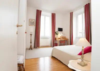 a white bedroom with a bed and a table at B&B Ondina in Rome