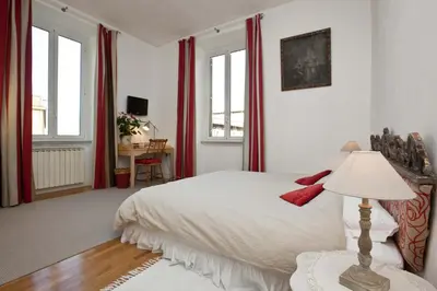 a bedroom with a white bed and red curtains at B&B Ondina in Rome