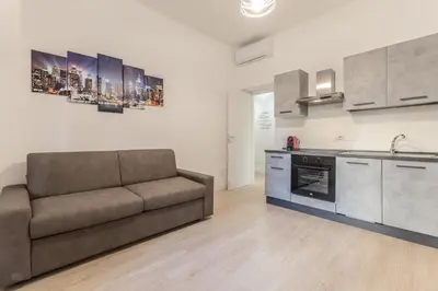 a living room with a couch and a kitchen at A Casa di Max - Battistini Station 