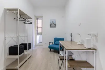 a white room with a desk and a blue chair at A Casa di Max - Battistini Station 