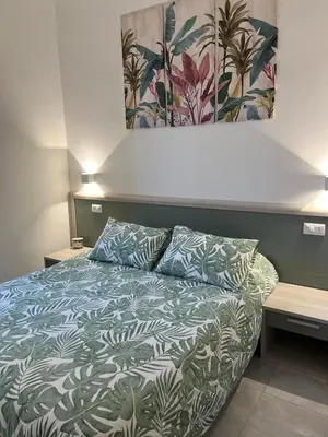 a bedroom with a bed with a blue and white comforter at Green apartment a Porta Pia in Rome