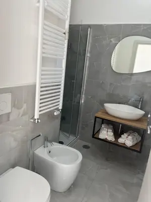 a bathroom with a sink and a toilet and a mirror at Green apartment a Porta Pia in Rome