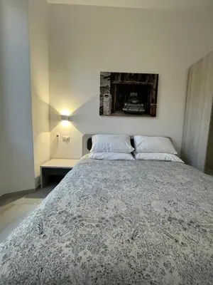 a bedroom with a bed with a picture on the wall at Green apartment a Porta Pia in Rome