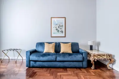 a blue couch in a living room with a table at BBHOME Eleganza e comfort unico in San Giovanni district in Rome