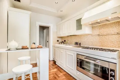 a kitchen with white cabinets and a stove at BBHOME Eleganza e comfort unico in San Giovanni district in Rome