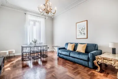 a living room with a blue couch and a table at BBHOME Eleganza e comfort unico in San Giovanni district in Rome