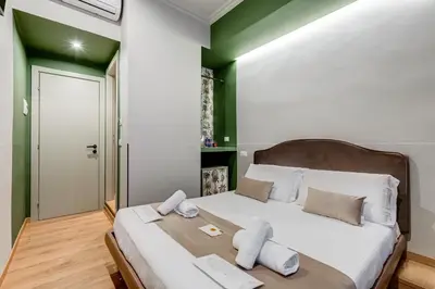 a bedroom with a large bed with green accents at Vivilo Collection - Charme 24 Suites - Close to Via Veneto in Rome