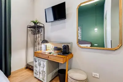 a room with a mirror and a table with a telephone at Vivilo Collection - Charme 24 Suites - Close to Via Veneto in Rome