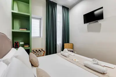 a hotel room with a bed and a tv at Vivilo Collection - Charme 24 Suites - Close to Via Veneto in Rome