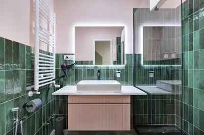 a green tiled bathroom with a sink and a mirror at Vatican Lante Suite in Rome