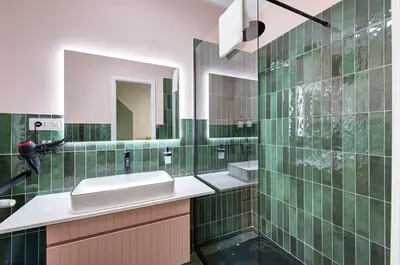 a green tiled bathroom with a sink and a mirror at Vatican Lante Suite in Rome