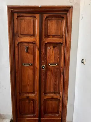 a wooden cabinet with two doors in a room at La casina sull'appia in Rome