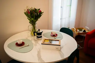 a white table with a book and a vase of flowers at La casina sull'appia in Rome