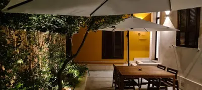 a wooden table with an umbrella in a patio at Trastevere incantevole con patio esterno privato in Rome