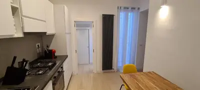 a kitchen with a stove and a table in it at Trastevere incantevole con patio esterno privato in Rome