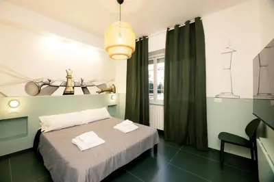 a bedroom with a bed and a chandelier at O Effe Games Vatican in Rome
