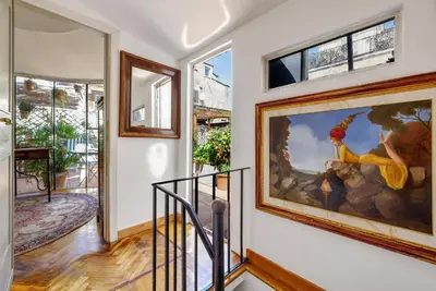 a living room with a red couch and a table at NOBILIA - Roof Garden Penthouse near Navona Square in Rome