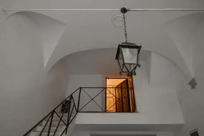 a chandelier hangs from a staircase in a house at NOBILIA - Roof Garden Penthouse near Navona Square in Rome