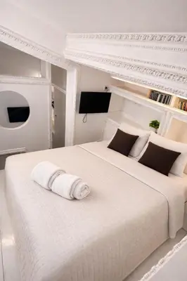 a white bedroom with a bed and a desk at Condotti Loft - city center in Rome