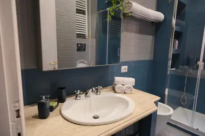 a bathroom with a sink and a toilet and a mirror at Casa Frida Arte e Sport tra MAXXI e Olimpico in Rome