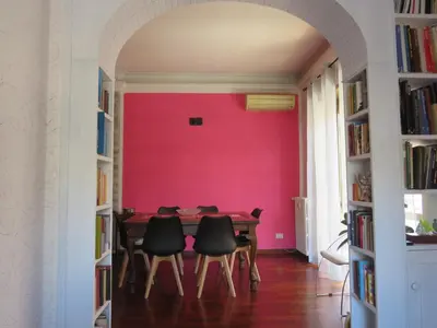 a dining room with a pink wall at Maddy House Roma in Rome