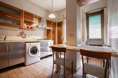 a kitchen with a washing machine and a washer at Maddy House Roma in Rome