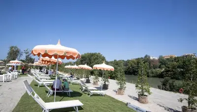 a group of chairs with umbrellas on a lawn at Maddy House Roma in Rome