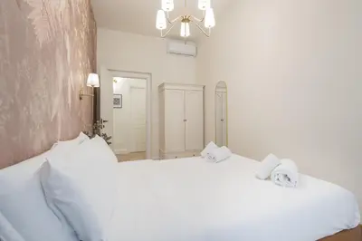 a white bedroom with a bed and a cabinet at NINA'S HOUSE - Monti Residences in Rome