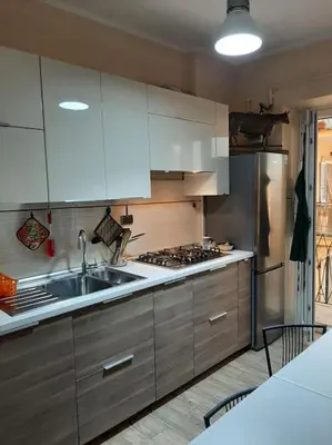 a kitchen with white cabinets and a stainless steel refrigerator at Casa Oscar in Rome