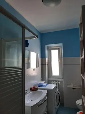 a blue bathroom with a sink and a toilet at Casa Oscar in Rome