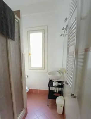 a white bathroom with a sink and a window at Bed Bike Breakfast al centro di Roma in Rome