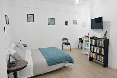a white bedroom with a bed and a table and a desk at Colli Albani Apartment in Rome