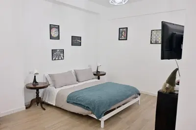 a bedroom with a bed and a flat screen tv at Colli Albani Apartment in Rome