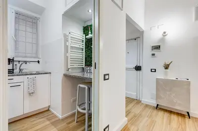 a kitchen with white cabinets and a sink at Vicolo Sereno Roma in Rome