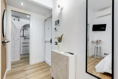 a mirror in a white room with a table at Vicolo Sereno Roma in Rome