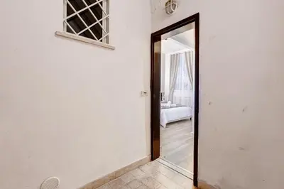 a hallway with a mirror and a room with a bed at Vicolo Sereno Roma in Rome