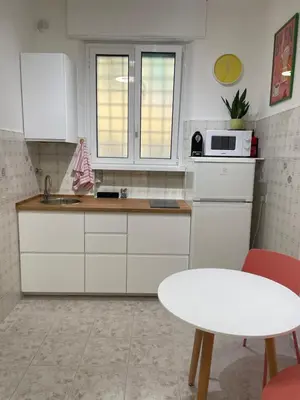 a kitchen with white cabinets and a white table at La Casita in Rome
