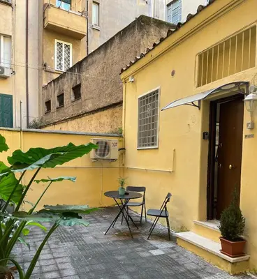 a patio with a table and chairs in front of a building at La Casita in Rome