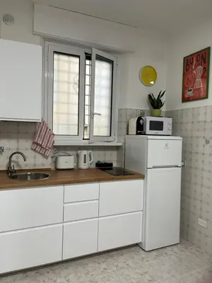 a kitchen with a white refrigerator and a microwave at La Casita in Rome