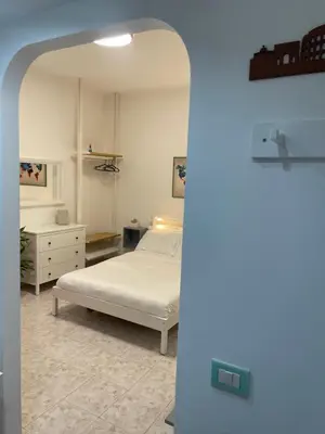 a bedroom with a white bed and a dresser at La Casita in Rome