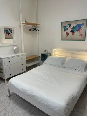 a bedroom with a white bed and a dresser at La Casita in Rome