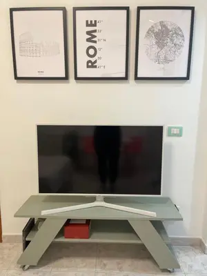 a coffee table in front of a tv with pictures on the wall at La Casita in Rome