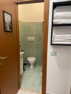 a small bathroom with a toilet and a door at La Casita in Rome